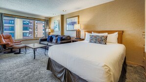 A hotel room with a large bed, a sofa, a chair, and a small table. - Village At Breck Liftside 4504 Studio (Breckenridge)