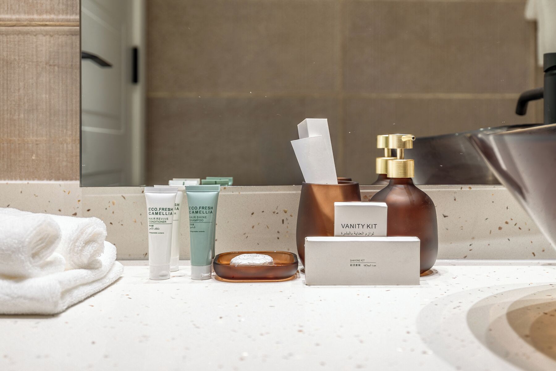 Uma toucador de banheiro com produtos de higiene pessoal, incluindo um kit de barbear, produtos para cabelo e um dispensador de sabão.