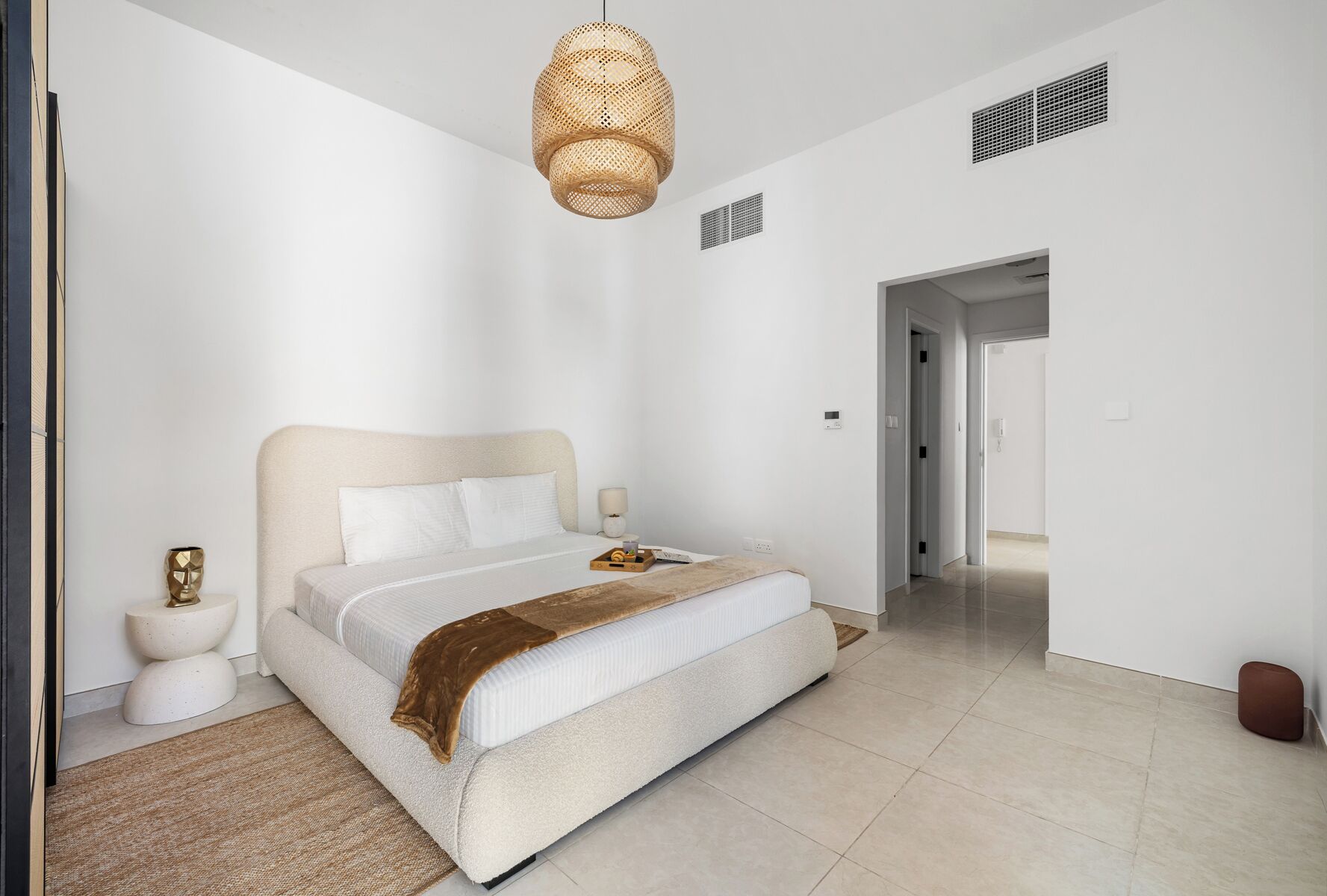 Une chambre à coucher moderne avec un grand lit, une table de chevet, une lampe et un luminaire suspendu.