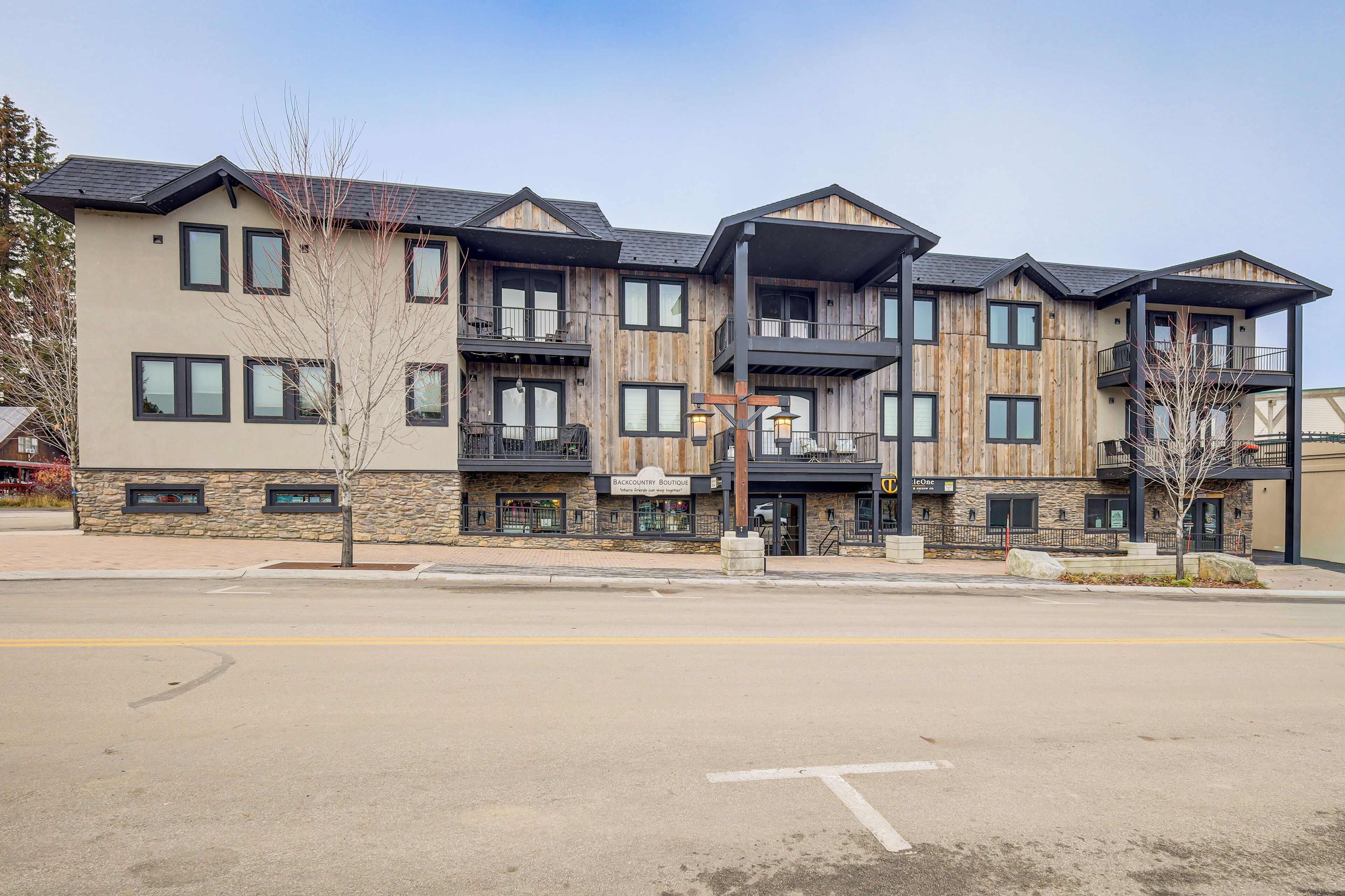 A multi-story building with a stone facade, balconies, and a ground-level entrance.