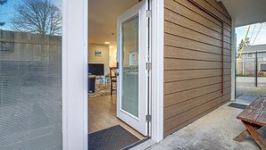 Una entrada de vivienda con un portón corredizo de vidrio que da a una sala de estar.