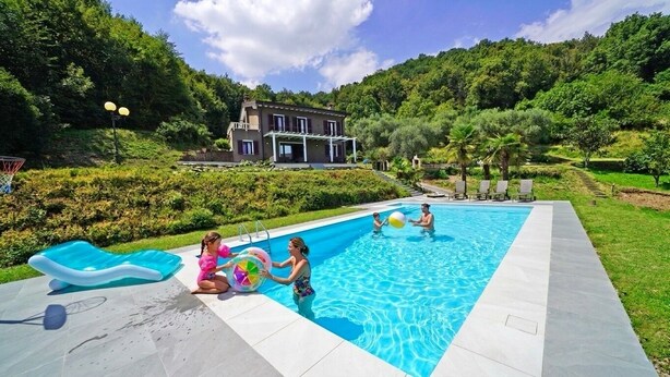 A swimming pool with a house in the background, surrounded by greenery. - D1MORA Sophie - exclusive privacy with view & pool (Salò)