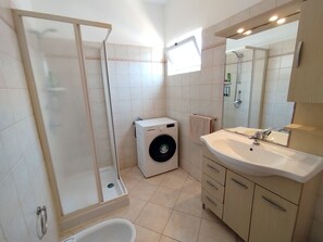 Een douche, een haardroger, een bidet, handdoeken