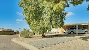 A residential driveway with a parked car, a tree, and a building with a garage. - 3 Mi to Lookout Mtn! Gem w/ Fire Pit + Fenced Yard (Phoenix)