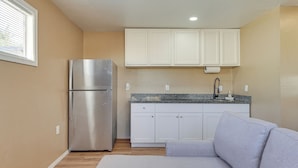 A compact kitchen with white cabinets, a stainless steel refrigerator, and a granite countertop. - 3 Mi to Lookout Mtn! Gem w/ Fire Pit + Fenced Yard (Phoenix)