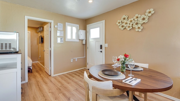 A dining area with a wooden table, chairs, and a decorative wall piece. - 3 Mi to Lookout Mtn! Gem w/ Fire Pit + Fenced Yard (Phoenix)