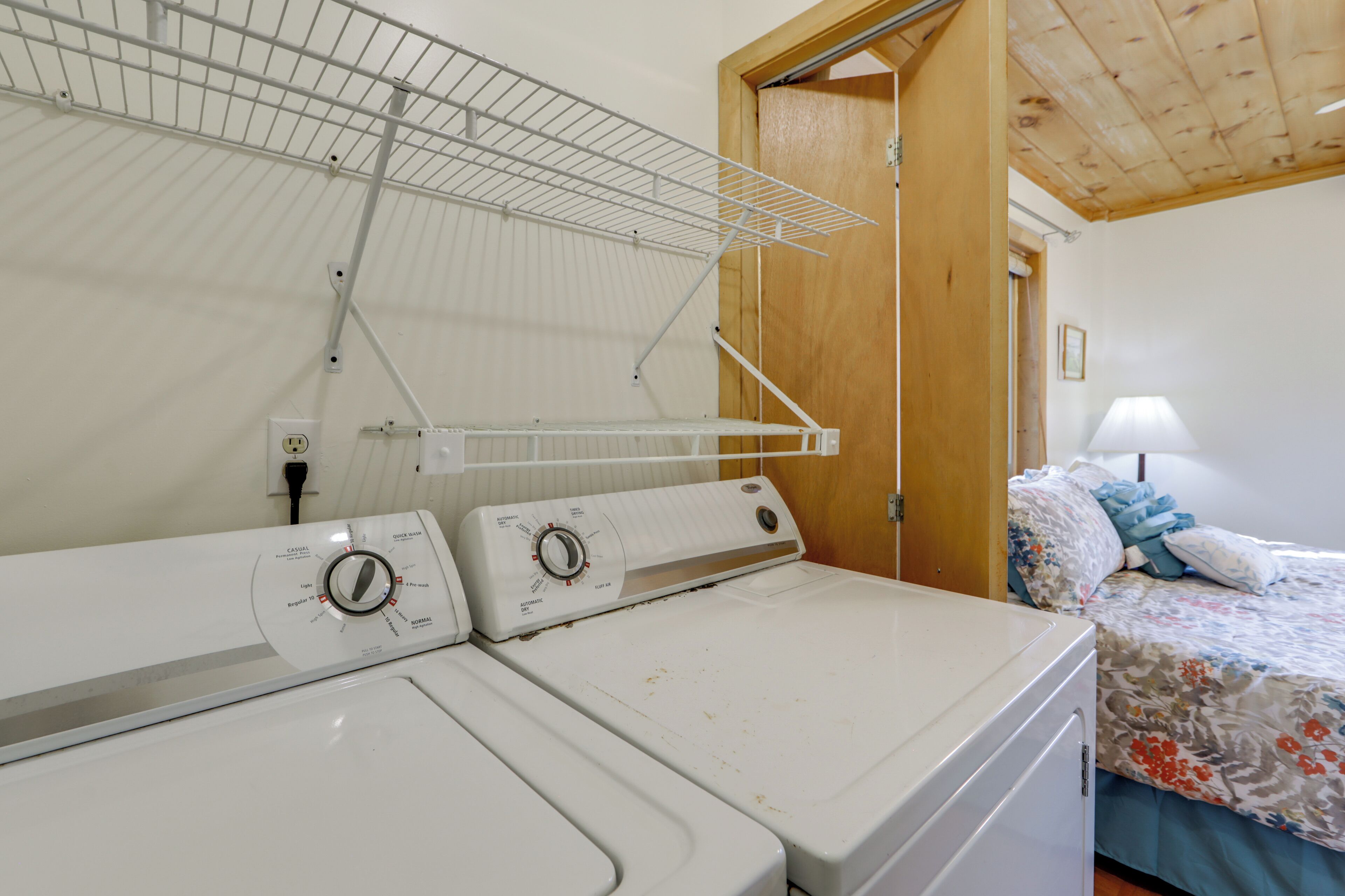 A laundry area with two washing machines and a drying rack.