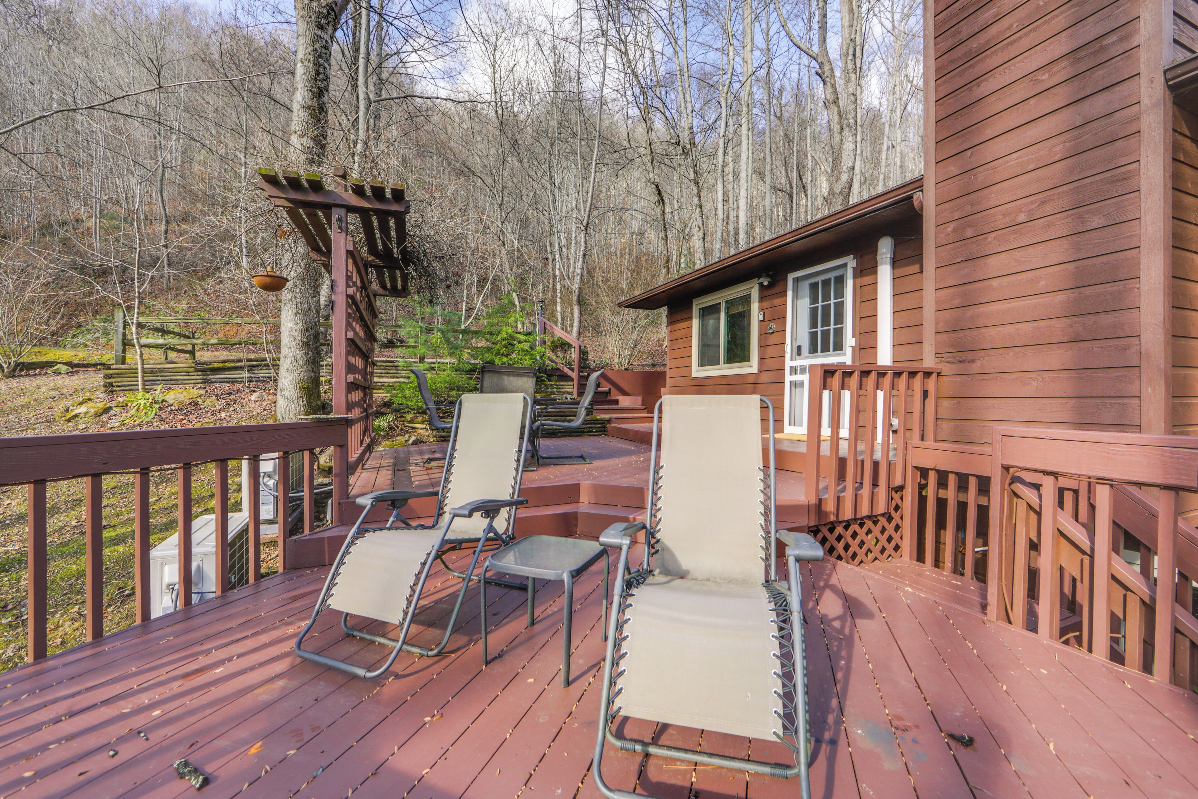A wooden deck with two lounge chairs and a pergola.