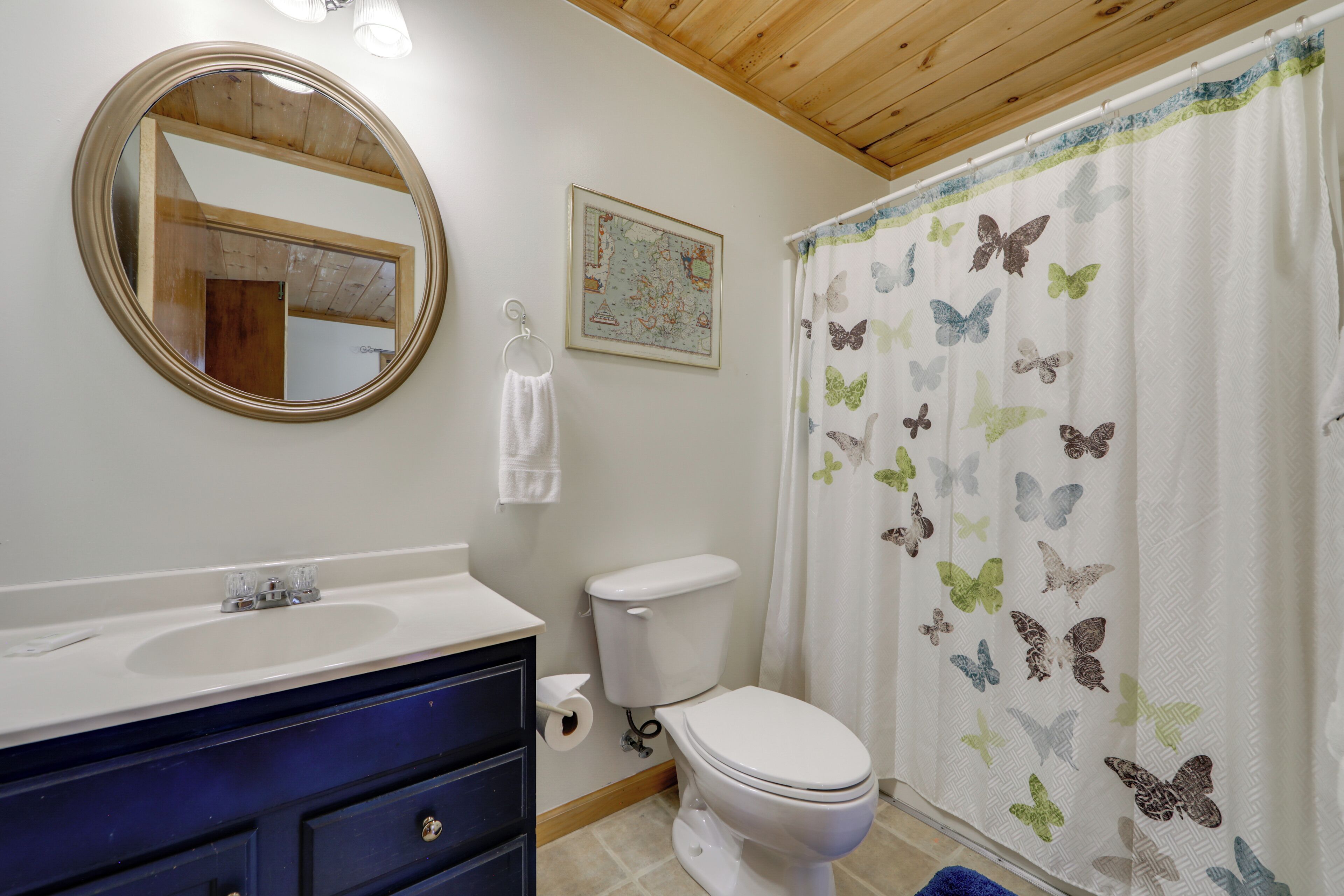 A bathroom with a sink, toilet, and a mirror.