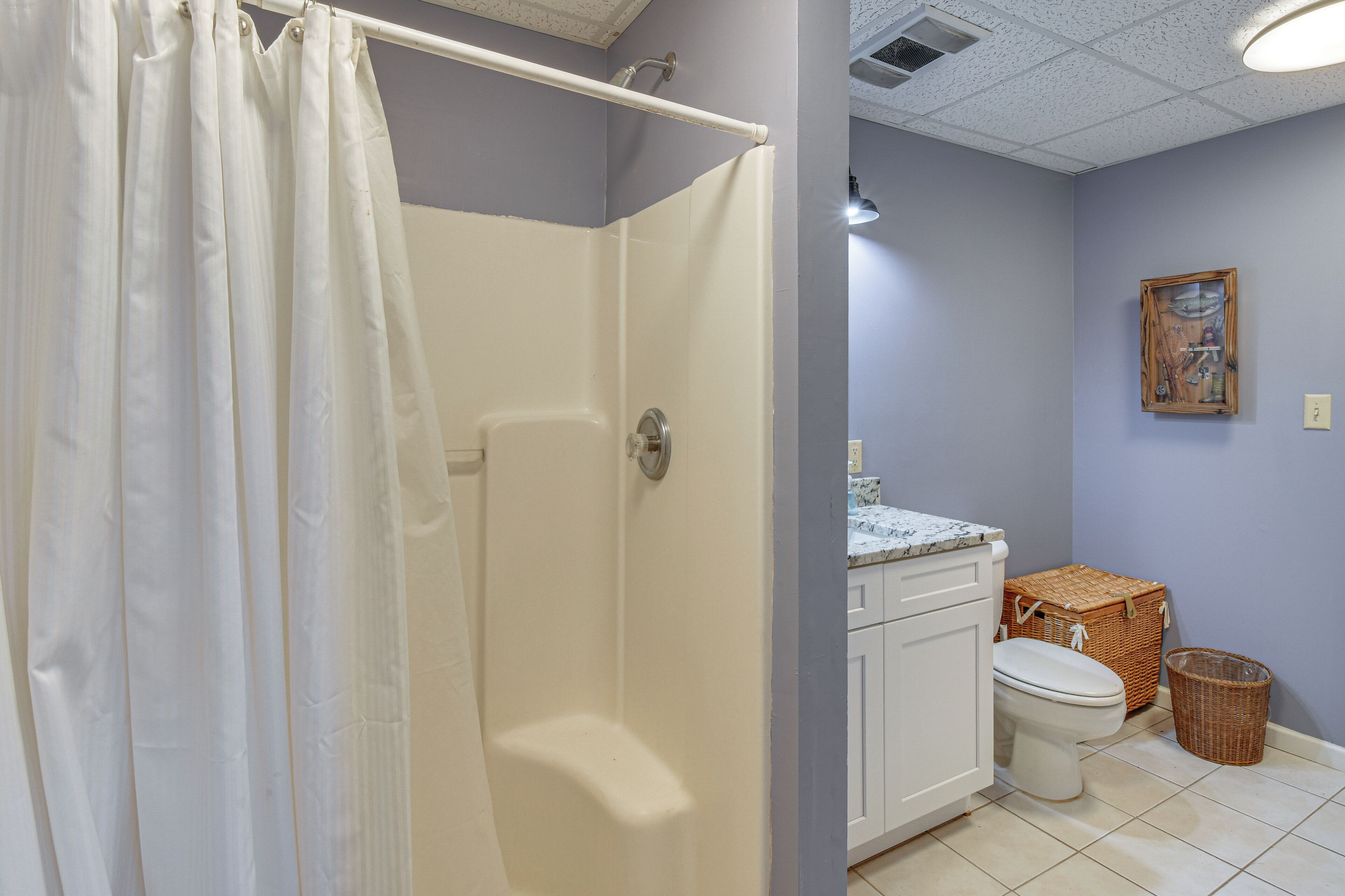 Ein Badezimmer mit Dusche, Toilette und Waschbecken.