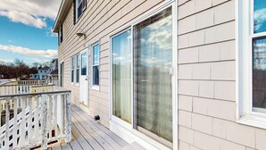 Une maison avec une terrasse en bois et de grandes fenêtres.
