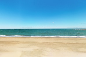 Ein Strand mit klarem, blauem Wasser und einem sandigen Ufer.