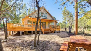 A cabin with a wooden deck, a covered porch, and a picnic table. - Pet-friendly Blue Ridge Cabin: Wraparound Deck! (Happy Jack)