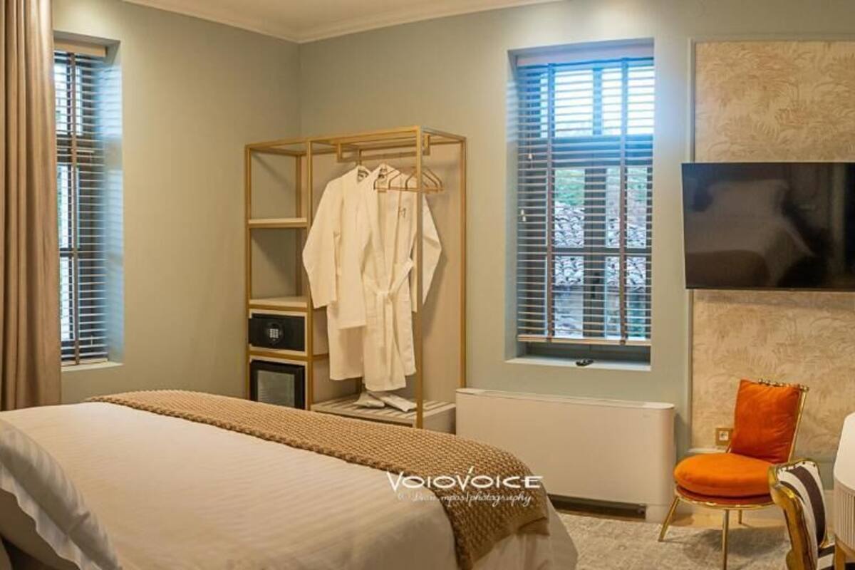 A bedroom with a bed, a wardrobe, a chair, and a radiator.