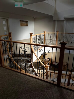 A wooden staircase with ornate black metal railings. - Star on Main with a Pool (Lower Plenty)