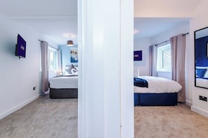 A hotel room with a bed, a window, and a door. - M22 | Near Airport | Parking | WiFi | 15% Off (Wythenshawe)