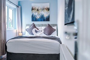 A hotel room with a bed, a painting on the wall, and a window with curtains. - M22 | Near Airport | Parking | WiFi | 15% Off (Wythenshawe)