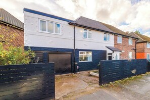A residential property with a garage, a front door, and a small garden area. - M22 | Near Airport | Parking | WiFi | 15% Off (Wythenshawe)