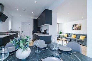Une cuisine moderne avec un coin repas, un canapé et un tableau au mur.