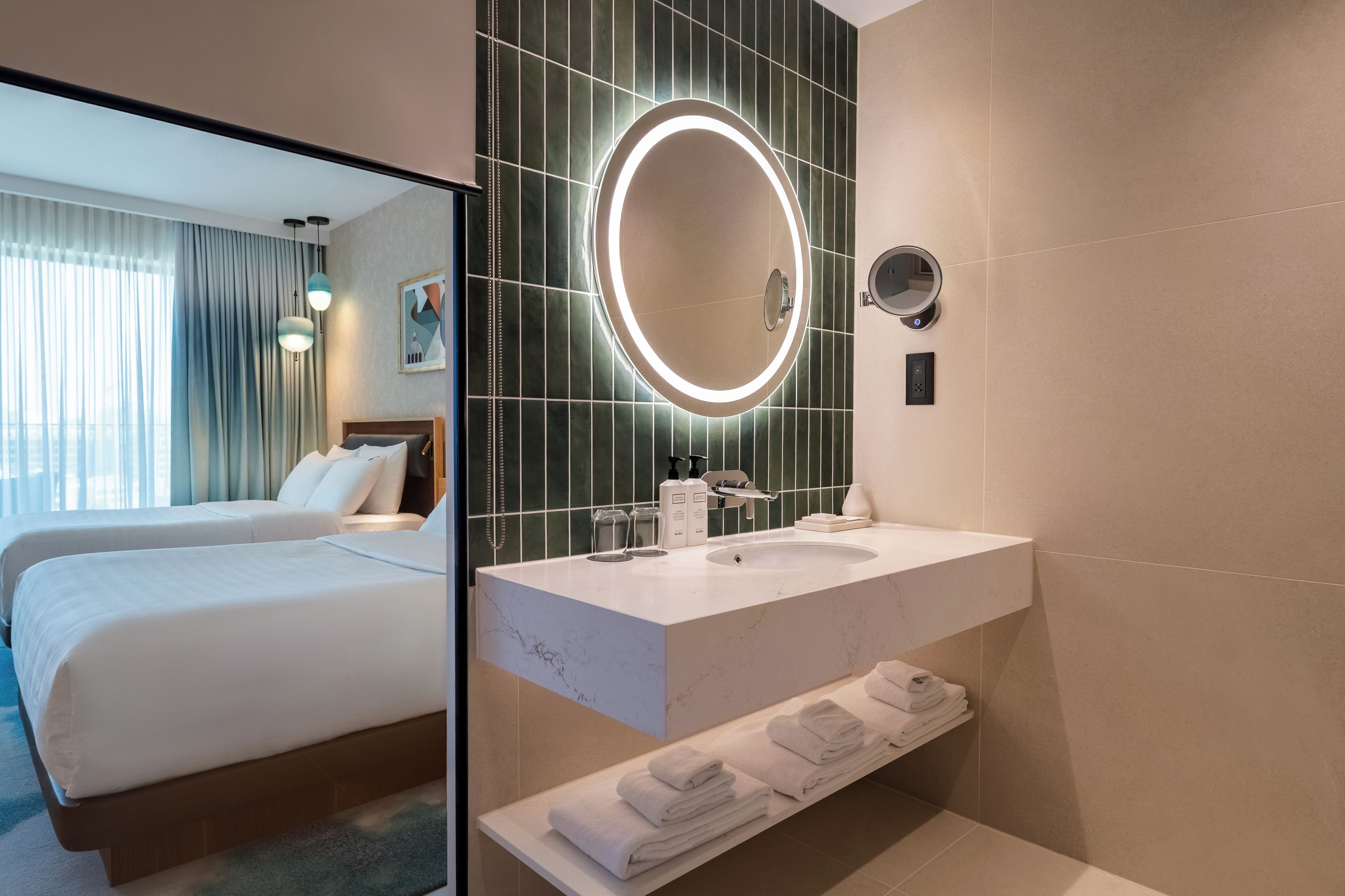 Ein Hotelzimmer mit einem Bett, einem Badezimmer mit Waschbecken und einem Spiegel.
