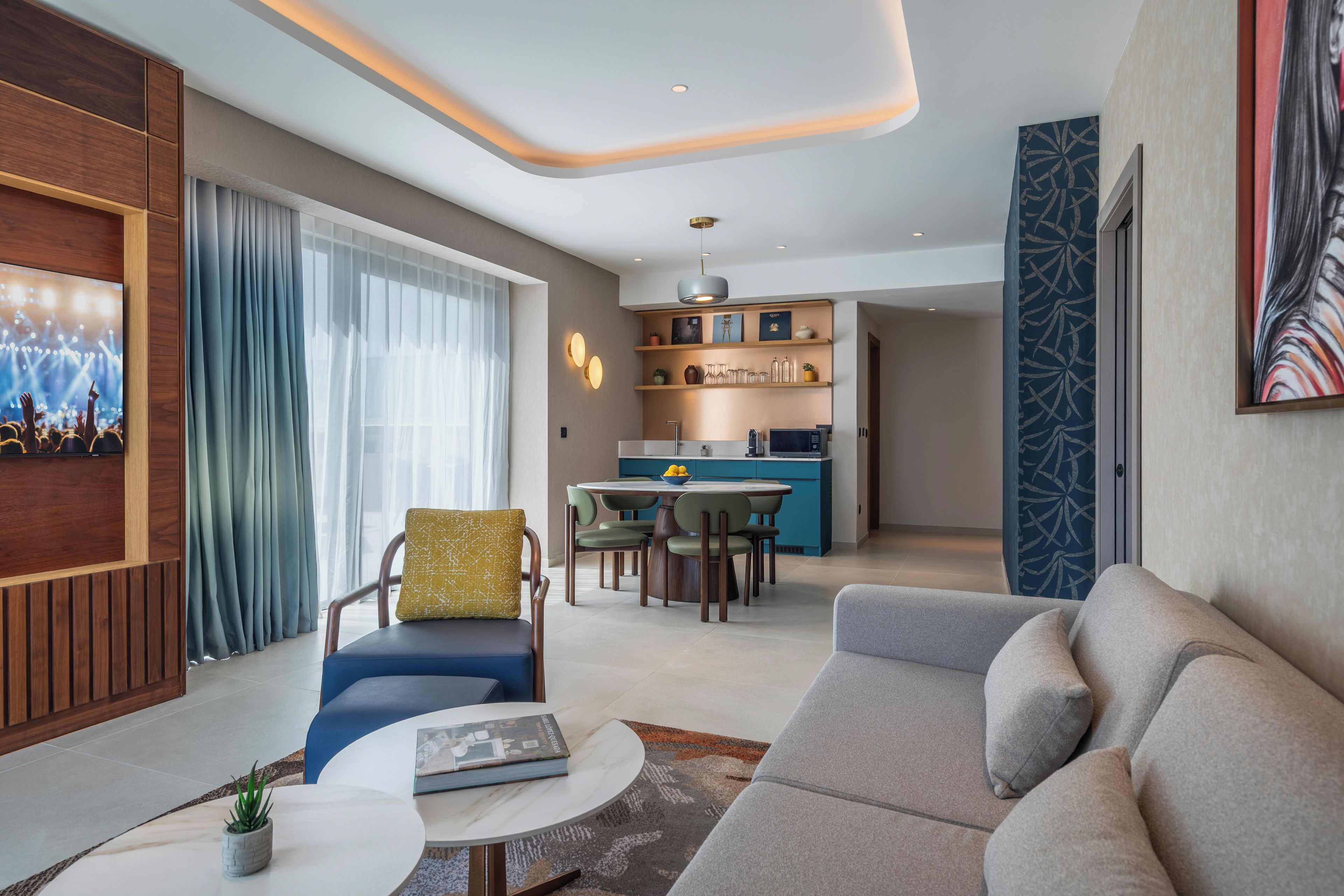 Una sala de estar moderna con un sofá, una mesa de comedor y una cocina al fondo.