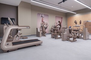 Un gimnasio moderno con cintas de correr, máquinas de pesas y equipo de ejercicio.
