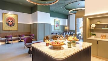 Un interior moderno con zona de bar, asientos y obras de arte.