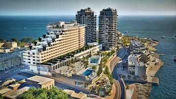 Un hotel moderno de gran altura con varios balcones, piscina y vista al mar.