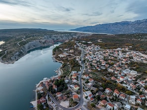 An aerial view of a coastal town with a winding road, houses, and a bridge over a river. - Villa The Family Zadarvillas (Jasenice)