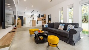 A modern living room with a grey sofa, yellow ottomans, and a round coffee table. - Villa The Family Zadarvillas (Jasenice)