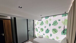 A modern bedroom with a large bed, a sliding glass door, and a curtain with a leaf pattern. - Tirana Room Rentals • Twin Room • Free Wi-Fi • Private Bathroom • Flat-Screen TV (Tirana)