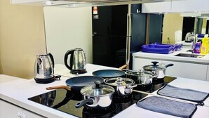 Una cocina moderna con estufa a gas, hervidor eléctrico y horno empotrado.