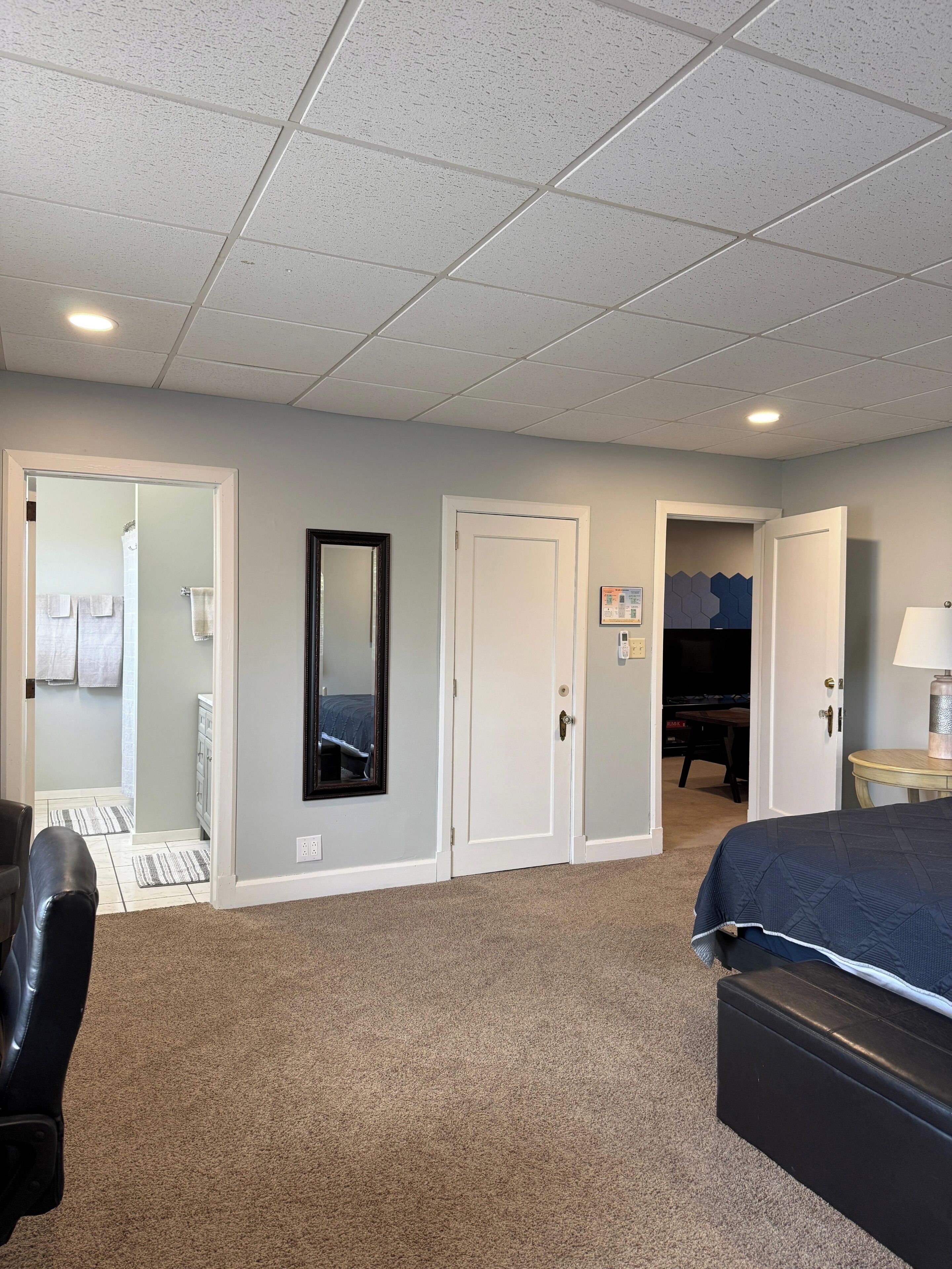 Une chambre d’hôtel avec un lit, un bureau, une chaise et une armoire.