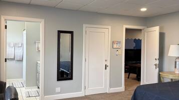 Une chambre d’hôtel avec un lit, un bureau, une chaise et une armoire.
