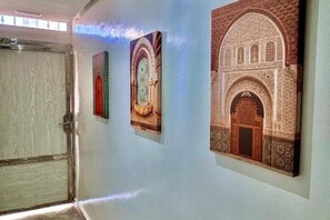 Ein Flur mit drei gerahmten architektonischen Entwürfen an der Wand.