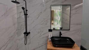 A modern bathroom with a shower, a sink, and a mirror.