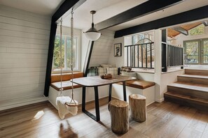 Ein gemütliches Zimmer mit einer Holzbänkl, einem Tisch und einer Hängelampe.