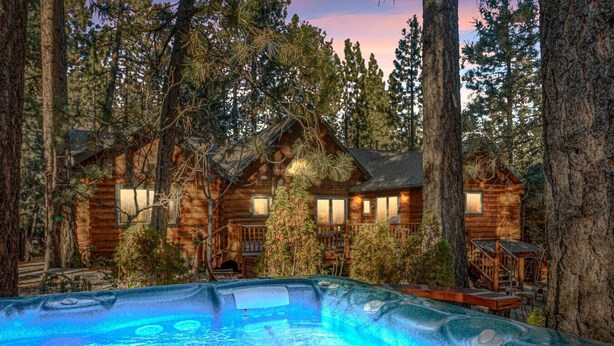 A log cabin with a hot tub surrounded by tall trees. - Honeycomb Hideaway| Hot Tub & Sauna, Large Yard (Big Bear Lake)