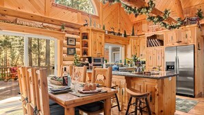 A wooden cabin interior with a kitchen, dining area, and large windows. - Honeycomb Hideaway| Hot Tub & Sauna, Large Yard (Big Bear Lake)