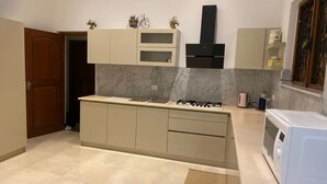 Una cucina moderna con schienale in marmo, piano cottura integrato e forno a microonde.