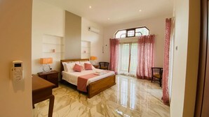 Una camera d'albergo con un letto grande, comodini, una scrivania e una sedia.