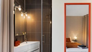 A modern bathroom with a glass shower enclosure, a white sink, and a mirror with lights. - Guest Room “La Drosera - Room No.6” with Shared Terrace, Garden & Wi-Fi (Riols)