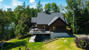 Une maison à deux étages avec un porche abrité, un garage et une pelouse bien entretenue.