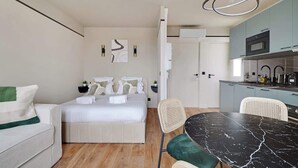 Une chambre d’hôtel moderne équipée d’un lit, d’une table à manger et d’une kitchenette.