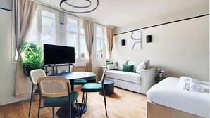 Une chambre d’hôtel moderne comprenant un coin repas, un canapé, un lit et une télévision.