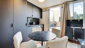 Eine moderne Küche mit Essbereich, einem Fernseher und einem Balkon mit Blick.