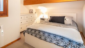 A bedroom with two beds, a dresser, a nightstand, and a window. - Splendid apartment, 3 bedrooms, sleeps 6, balcony with mountain views (Morillon)