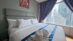 Ein Hotelzimmer mit einem großen Bett, einem Kopfteil, Blick auf die Stadt und einem Bild an der Wand.