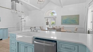 A spacious kitchen with a large island, white cabinetry, and a modern chandelier. - Renovated to Studs in Seaside w/3K Kings! 5 Min Walk to Beach + 2 Bikes! (Santa Rosa Beach)