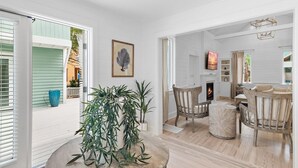 A spacious living room with a fireplace, wooden furniture, and a large plant. - Renovated to Studs in Seaside w/3K Kings! 5 Min Walk to Beach + 2 Bikes! (Santa Rosa Beach)